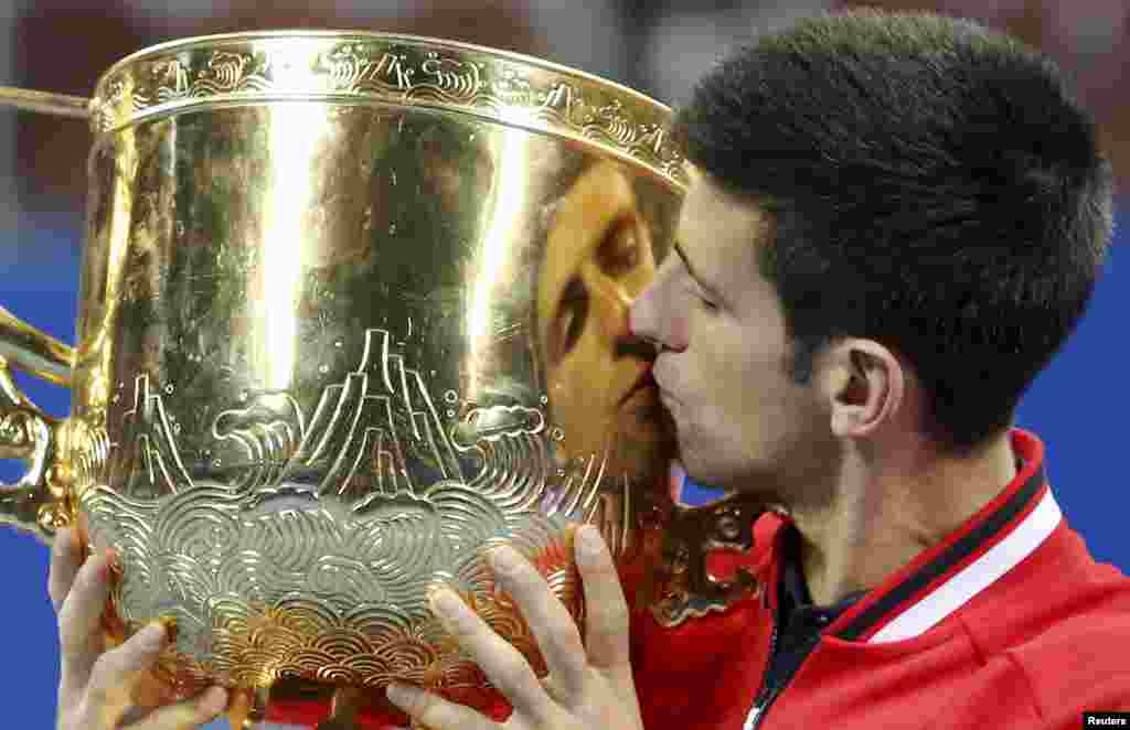 Novak Djokovic of Serbia kisses his trophy after winning the men&#39;s singles final match against Rafael Nadal of Spain at the China Open Tennis Tournament in Beijing, China.