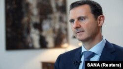 FILE - Syria's President Bashar al-Assad speaks during an interview with the Iranian Khabar TV channel in this handout photograph released by Syria's national news agency SANA, Oct. 4, 2015. 