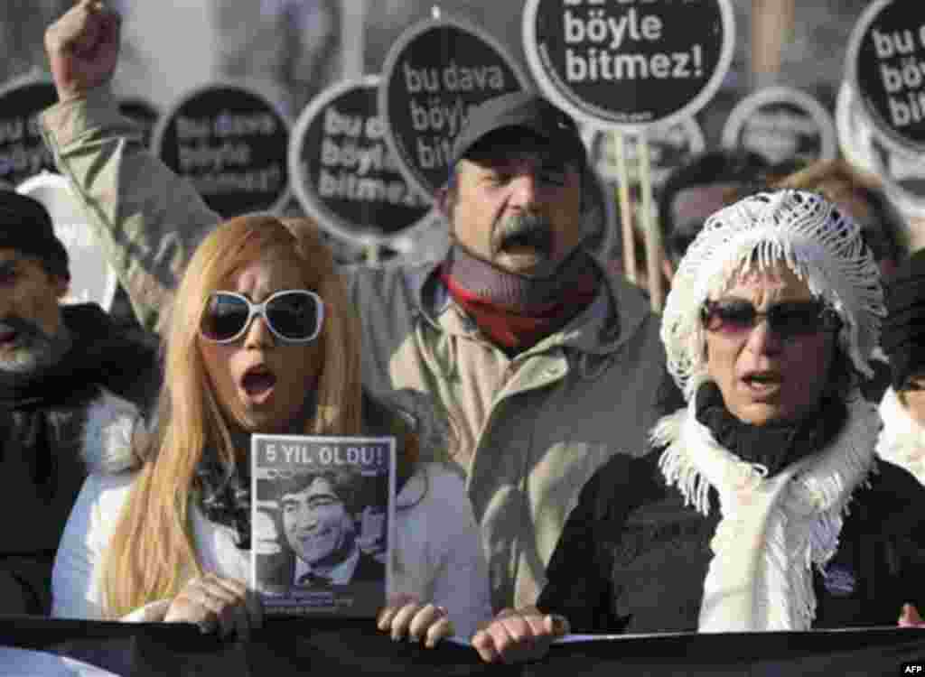 Hundreds of people hold placards that read 'This case won't end this way' outside a courthouse in Istanbul, Turkey, Tuesday, Jan. 17, 2012. A prosecutor is demanding life imprisonment for seven men accused of involvement in the killing of an ethnic Armen