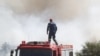 Seorang petugas pemadam kebakaran memperhatikan asap yang mengepul dalam kebakaran yang melanda wilayah Kitsi, di pinggiran selatan Athena, pada 19 Juni 2024. (Foto: Sotiris Dimitropoulos/Eurokinissi/AFP)