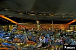 Migrants prepare for a night's sleep on the deck of the Medecins sans Frontieres (MSF) ship Bourbon Argos off the coast of Libya, August 7, 2015.