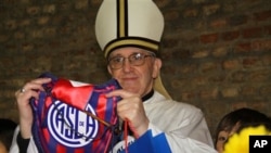 In this March 24, 2011 image released by the San Lorenzo de Almagro soccer team on March 13, 2013, Argentina's Cardinal Jorge Bergoglio holds up a small flag of the San Lorenzo soccer team in Buenos Aires, Argentina.