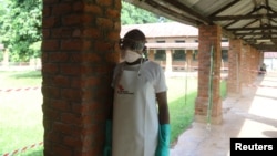 A health worker prepares to takes off protective clothing after visiting the isolation ward at Bikoro hospital, which received a new suspected Ebola case, in Bikoro, Democratic Republic of Congo, May 12, 2018. 
