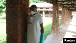 A health worker prepares to take off protective clothing after visiting the isolation ward at Bikoro hospital, which received a new suspected Ebola case, in Bikoro, Democratic Republic of Congo, May 12, 2018. 