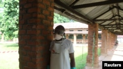 Un agent de santé s'apprête à retirer ses vêtements de protection après avoir visité le service d'isolement de l'hôpital de Bikoro, en République démocratique du Congo, le 12 mai 2018.