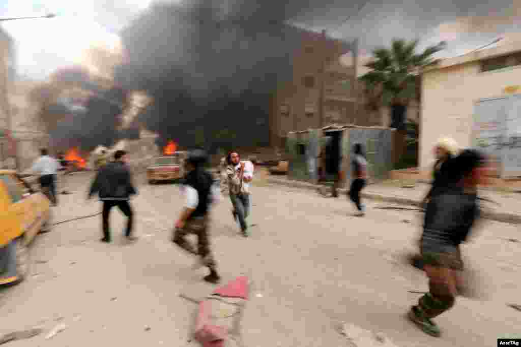 A man runs with an injured child after what activists said was shelling by forces loyal to Syria&#39;s president Bashar al-Assad on Al-Dubeit neighborhood in Idlib city.