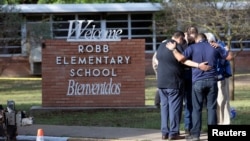 People gather at Robb Elementary School, the scene of a mass shooting in Uvalde, Texas, U.S. May 25, 2022. (REUTERS/Nuri Vallbona)