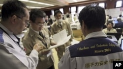 Teams of government and nuclear specialists at the emergency rescue headquarters analyze data from the leaked radiation from the Fukushima nuclear facilitiesin Fukushima, Japan, March 19, 2011