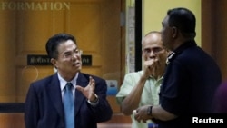 부검을 위해 김정남의 시신이 안치된 말레이시아 쿠알라룸푸르 병원에서 15일 북한 대사관 직원(왼쪽)이 말레이시아 경찰 관계자와 대화하고 있다.