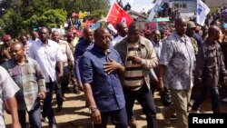 Democratic Republic of Congo's President Joseph Kabila (front C) walks along a street in Bunagana, a town formerly held by M23 rebels, in eastern Democratic Republic of the Congo, Nov. 30, 2013.