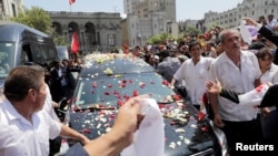 El coche fúnebre que lleva los restos del expresidente de Perú, Alan García, quien se suicidó esta semana, se abre paso entre la multitud de simpatizantes en Lima, Perú.