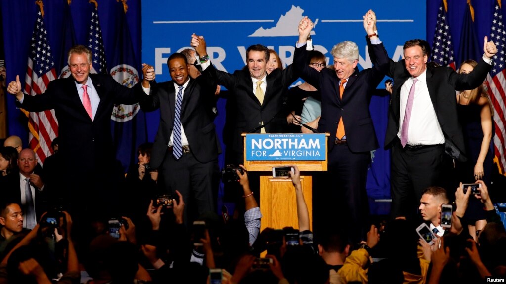 El demócrata Ralph Northam (centro) celebra su triunfo por la gobernación de Virginia junto al gobernador saliente, Terry McAuliffe (extremo izquierdo) y otros funcionarios electos.