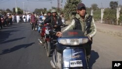 Indian journalists walk with their two wheelers at the funeral procession of fellow journalist Bwizamani Singh in Imphal, India, Tuesday, Dec. 25, 2012.