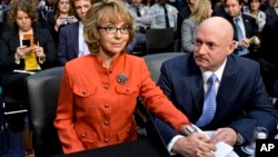 FILE - Former U.S. Rep. Gabrielle Giffords, who survived a gunshot to the head in 2011 during a mass shooting in Tucson, Arizona, sits with her husband, retired astronaut Mark Kelly, at a Senate panel hearing on gun violence, on Capitol Hill in Washington, Jan. 30, 2013.