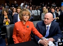 FILE - Former U.S. Rep. Gabrielle Giffords, who survived a gunshot to the head in 2011 during a mass shooting in Tucson, Ariz., sits with her husband, retired astronaut Mark Kelly, at a Senate panel hearing on gun violence, on Capitol Hill in Washington.