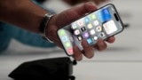 In this file photo, a person holds an iPhone 15 Pro at the Apple campus, Sept. 12, 2023, in Cupertino, Calif. (AP Photo/Jeff Chiu, File)