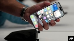 In this file photo, a person holds an iPhone 15 Pro at the Apple campus, Sept. 12, 2023, in Cupertino, Calif. (AP Photo/Jeff Chiu, File)