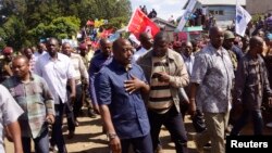 Democratic Republic of Congo's President Joseph Kabila (front C) walks along a street in Bunagana, a town formerly held by M23 rebels, in eastern Democratic Republic of the Congo, Nov. 30, 2013.