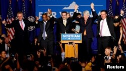 El demócrata Ralph Northam (centro) celebra su triunfo por la gobernación de Virginia junto al gobernador saliente, Terry McAuliffe (extremo izquierdo) y otros funcionarios electos.