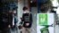 FILE - People walk by a poster reading in Vietnamese "Fighting COVID-19" in Hanoi, Vietnam, Apr. 23, 2020. Business activities are resuming in Vietnam as the country lifts the nationwide lockdown to contain the spread of COVID-19.