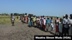FILE - Hundreds of people wait in line in the town of Koch in South Sudan to receive food aid from the World Food Program.