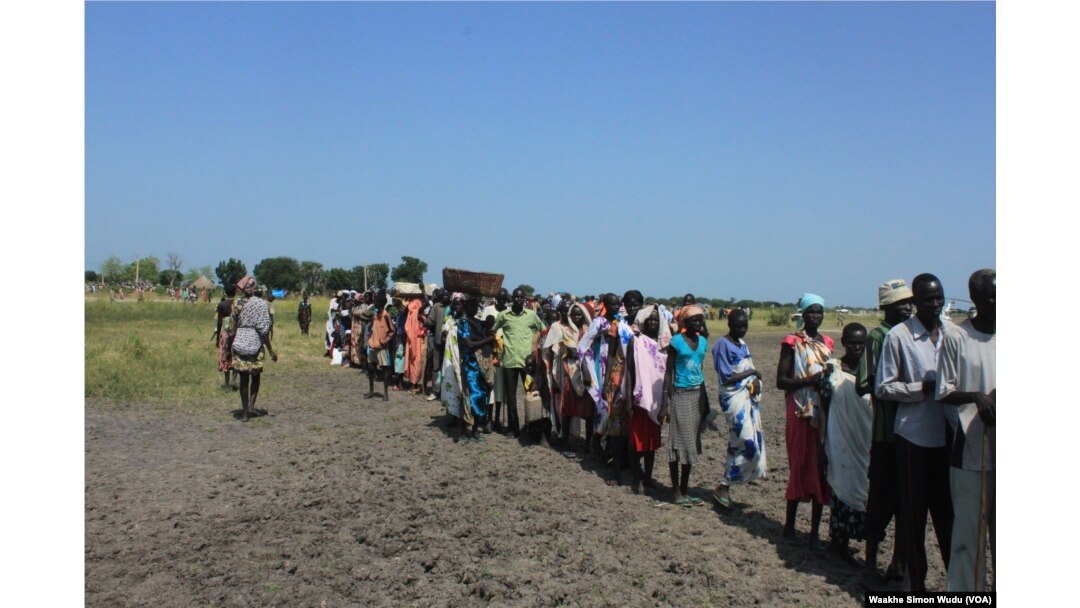 FILE - Hundreds of people wait in line in the town of Koch in South Sudan to receive food aid from the World Food Program on Friday, Aug. 25, 2015. Aid agencies stopped deliveries to Koch in May, after a sharp surge in violence there.