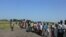 Hundreds of people wait in line in the town of Koch in South Sudan to receive food aid from the World Food Program on Friday, Aug. 25, 2015. Aid agencies stopped deliveries to Koch in May, after a sharp surge in violence there. 