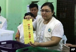 Myanmar election commission officer shows a ballot to count votes at a polling station during the country’s general election, Nov. 8, 2015, in Yangon.