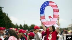 FILE - In this Aug. 2, 2018, file photo, a protesters holds a Q sign waits in line with others to enter a campaign rally with President Donald Trump in Wilkes-Barre, Pa. 