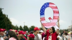 Demonstrant sa znakom Q pred miting Donalda Trumpa (Foto: AP/Matt Rourke)