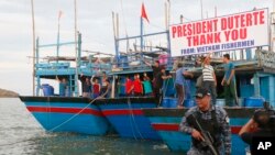 Ngư dân Việt Nam vẫy chào tạm biệt Tổng thống Philippines sau khi bị bắt vì đánh bắt trái phép hồi năm ngoái.