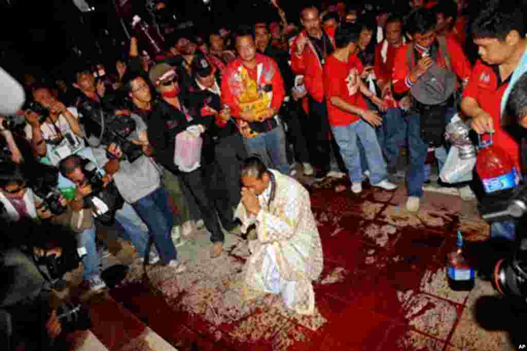 A Hindu priest (C) performs a ritual after red-shirted supporters of deposed Thai premier Thaksin Shinawatra spilled blood at Prime Minister Abhisit Vejjajiva's Democrat party offices in Bangkok on March 16, 2010.