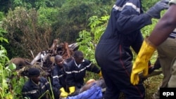 Une équipe de secours tranporte le corps de l'une des victimes d'un accident de voiture dans la forêt de Mabira, à environ 30kms de la capitale ougandaise, 14 février 2004. epa/ HENRY BONYEREIWE