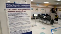 A sign about COVID-19 is displayed in a waiting room at the Valley Health Center TB/Refugee Program in San Jose, California on Dec. 9, 2021.