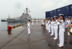 资料照片：美国海军“本福德”号导弹驱逐舰抵达中国山东省的青岛港时，一支中国军乐队开始演奏。（2016年8月8日）
