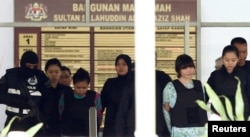 FILE - Vietnamese Doan Thi Huong and Indonesian Siti Aisyah who are on trial for the killing of Kim Jong Nam, the estranged half-brother of North Korea's leader, are escorted as they leave the Shah Alam High Court on the outskirts of Kuala Lumpur, Malaysia.