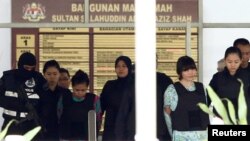Vietnamese Doan Thi Huong and Indonesian Siti Aisyah who are on trial for the killing of Kim Jong Nam, the estranged half-brother of North Korea's leader, are escorted as they leave the Shah Alam High Court on the outskirts of Kuala Lumpur, Malaysia, Oct. 3, 2017,