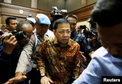 FILE - Policeman guards as former Indonesian parliament speaker Setya Novanto (C) attends court for his verdict in Jakarta, Indonesia, April 24, 2018.