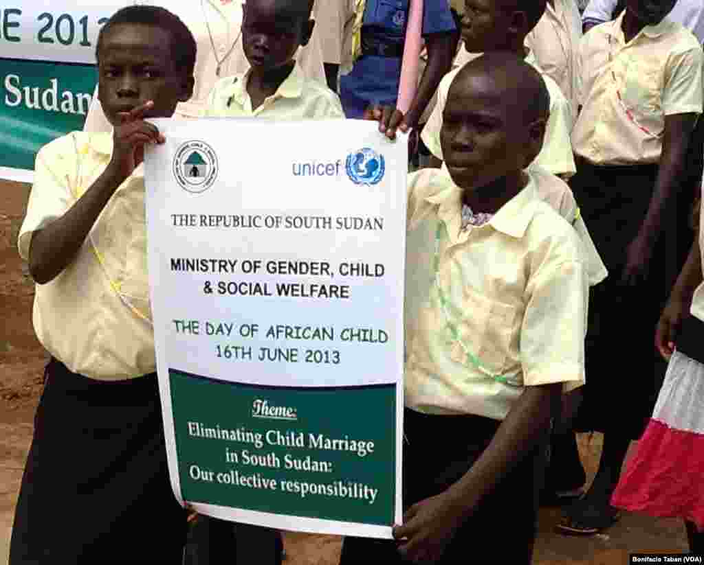 Anak-anak sekolah di Juba, Sudan Selatan, memegang poster kampanye penghapusan pernikahan di bawah umur. Pernikahan di bawah umur oleh banyak warga negara itu sebaga cara bagi keluarga untuk mendapatkan sumber daya dan kekayaan dari pembayaran mahar, menurut laporan Human Rights Watch. 
