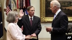 Holly Knowlton Petraeus holding the family bible as her husband David Petraeus is sworn in by Vice President Joe Biden as CIA Director, in the Roosevelt Room of the White House in Washington, September 6, 2011.