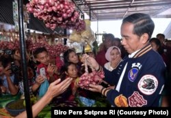 Presiden Joko Widodo berbincang dengan seorang pedagang saat mengunjungi Pasar Rakyat Balige di Sumatera Utara, Jumat, 15 Maret 2019. (Foto: Biro Pers Setpres RI)