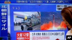 Seorang perempuan berjalan melewati layar televisi yang menyiarkan berita peluncuran rudal Korea Utara, di Tokyo, 29 Agustus 2017. Korea Utara menembakkan sebuah rudal balistik dari ibukota Pyongyang yang melayang di atas Jepang sebelum jatuh di sebela utara Samudera Pasifik. (AP Photo/Shizuo Kambayashi) 