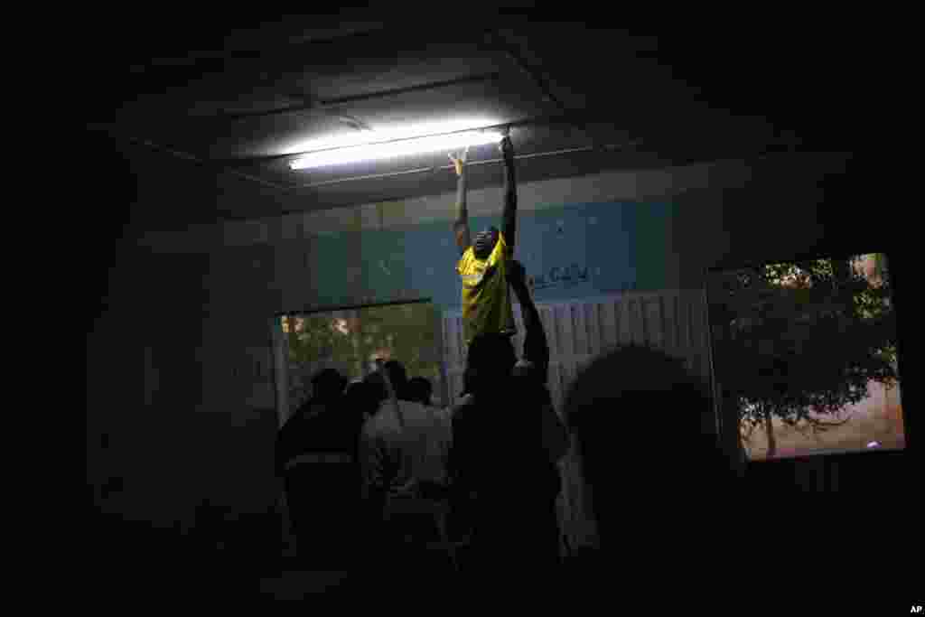 A boy changes a light fixture at a polling station during Mali&#39;s parliamentary elections in Gao, Nov. 24, 2013. 