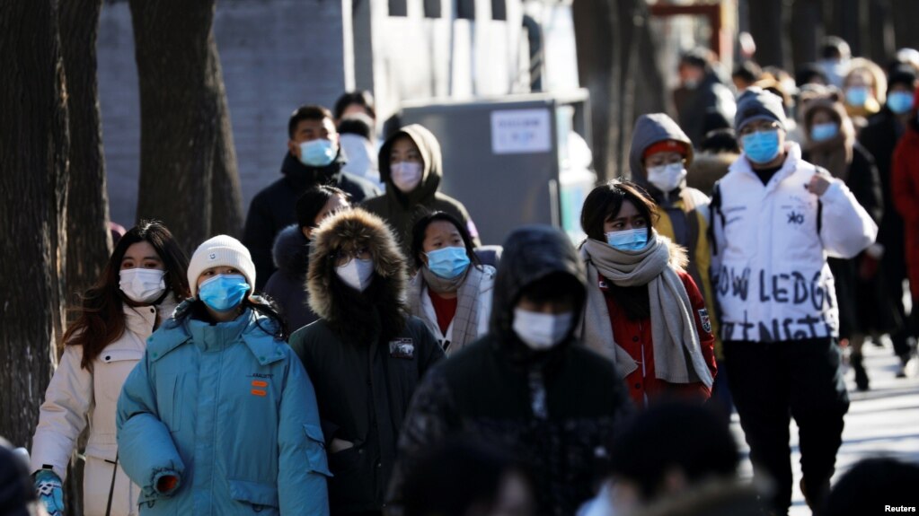 身穿厚保暖外衣的人群走过北京南锣鼓巷。（2021年1月16日）