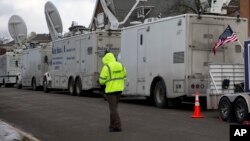 Satellite trucks line the street on the campus of Drake University in Des Moines, Iowa, Jan. 28, 2016.