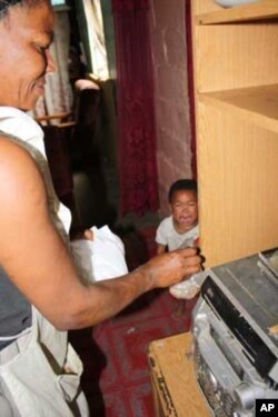 A mother cooks while her child screams for attention in a home in South Africa's Western Cape, which has one of the highest rates of Fetal Alcohol Syndrome in the world