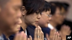 Tenaga sukarela dari asosiasi Buddhist di Taiwan berdoa bagi para penumpang asal China dalam pesawat Malaysia Airlines penerbangan MH370, di sebuah hotel di Beijing (1/4). (AP/Andy Wong)