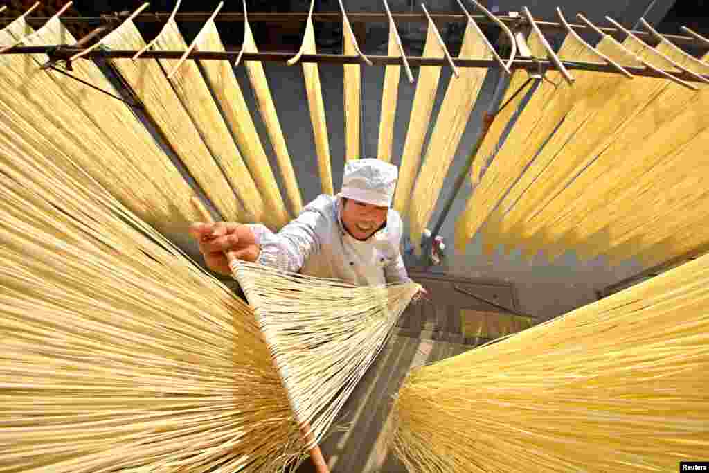 A villager dries hand-made noodles in Linyi, Shandong province, China, Nov. 21, 2017.