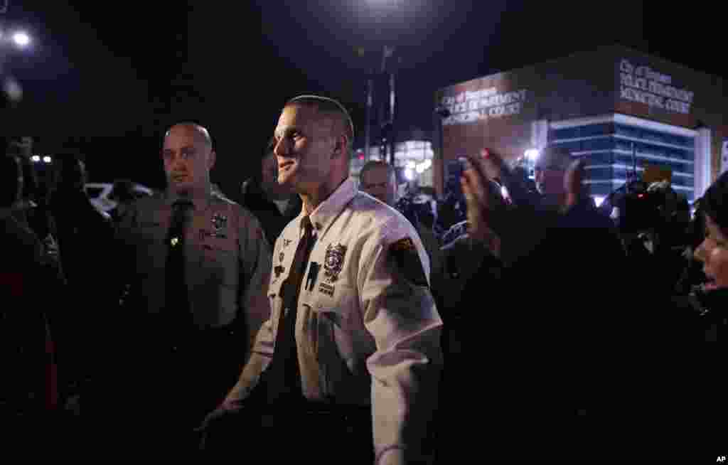 St. Louis Police Department Lt. Jerry Lohr walks through a crowd of protesters trying to get them to move away from the Ferguson Police Department, March 12, 2015.