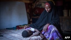 Amran Mahamood, qui gagne sa vie depuis 15 ans en excisant des jeunes filles, est assis à côté d'une fille le 19 février 2014 à Hargeysa. (Photo Nichole Sobecki /AFP)